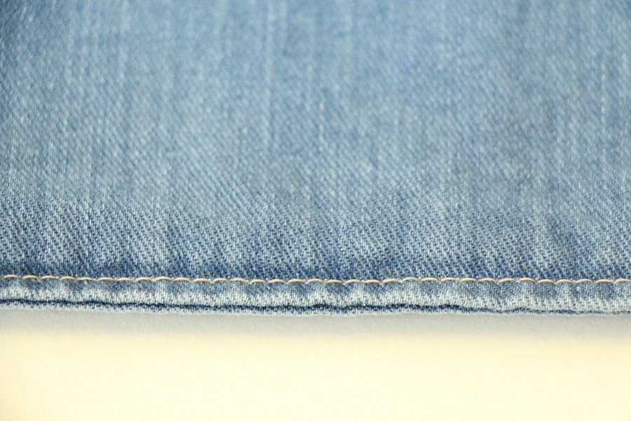 A denim waistband seam seen from the side.