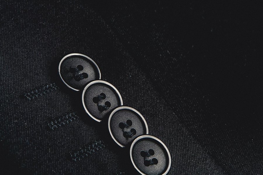 Four horn buttons on a navy wool jacket.