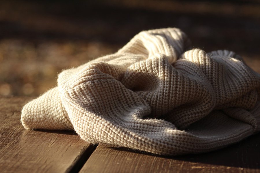 A folded cream rib-knit garment.