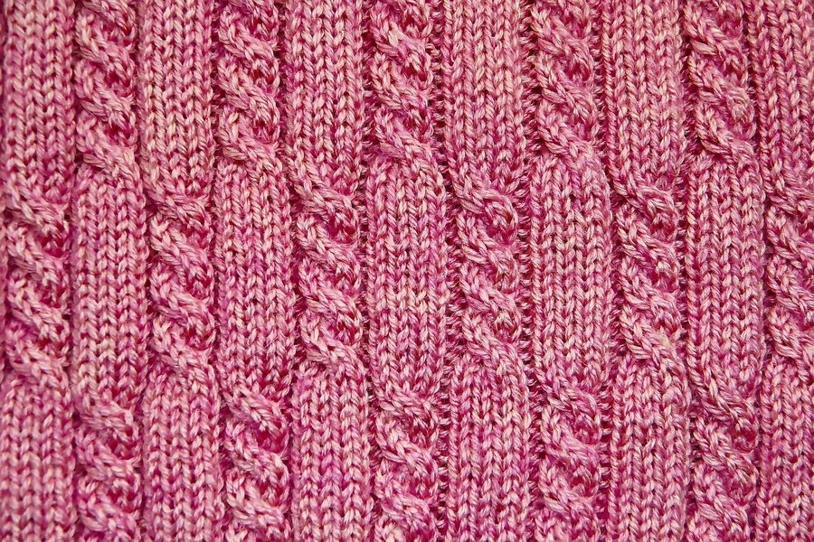 A close-up of a pink cable knit.