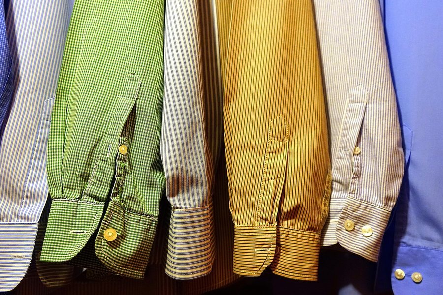 Shirts in several colours on a rail.