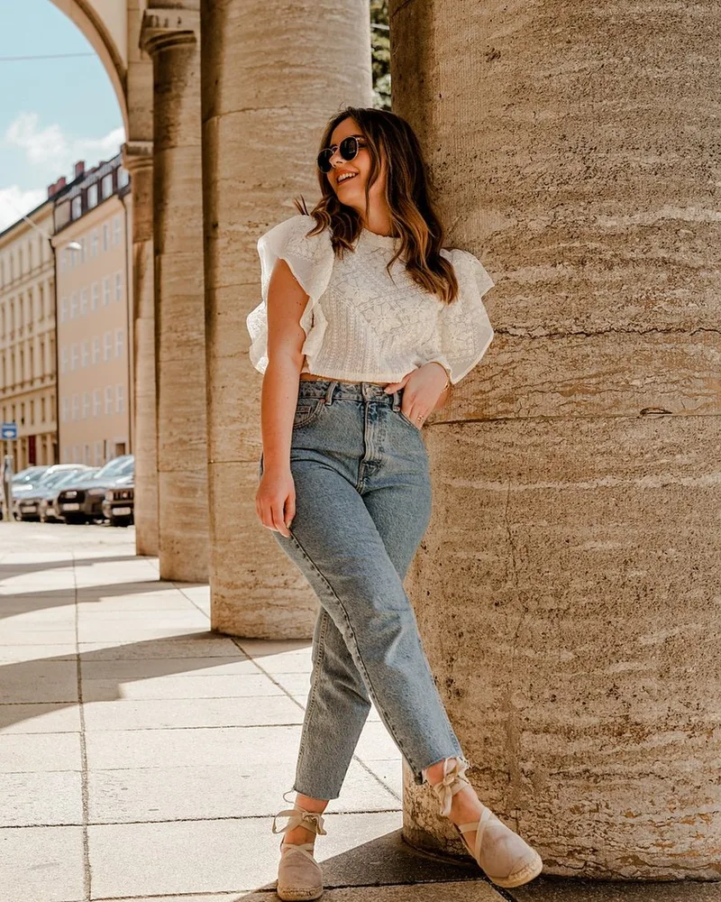 A blazer layered over a plain tee, worn with straight trousers.