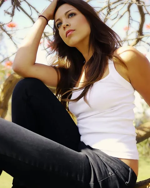 A woman sitting in dark skinny jeans.