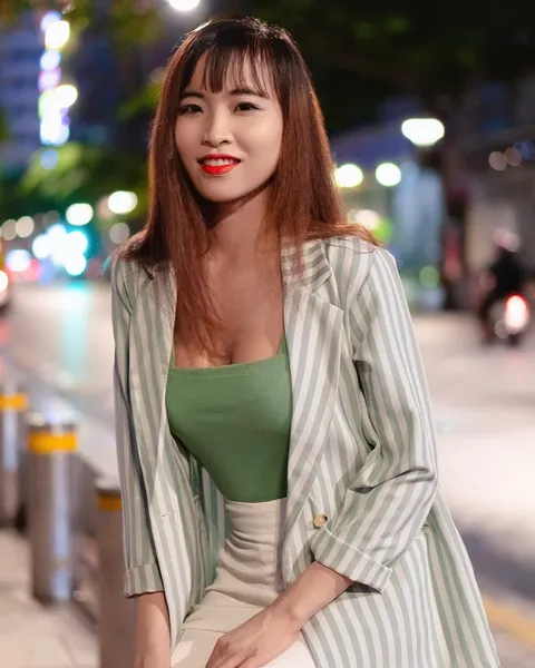 A woman in a green top with a striped overshirt.