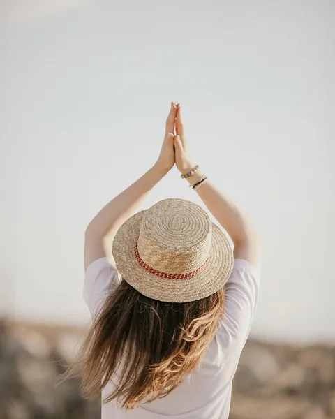 A woman in a white T-shirt photographed from behind.