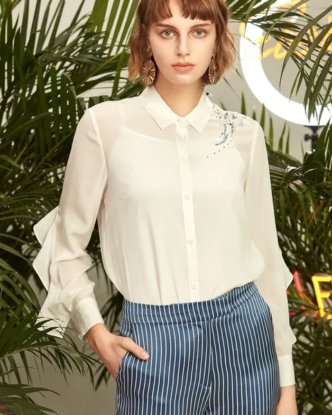 A woman in a striped shirt with pinstripe trousers.