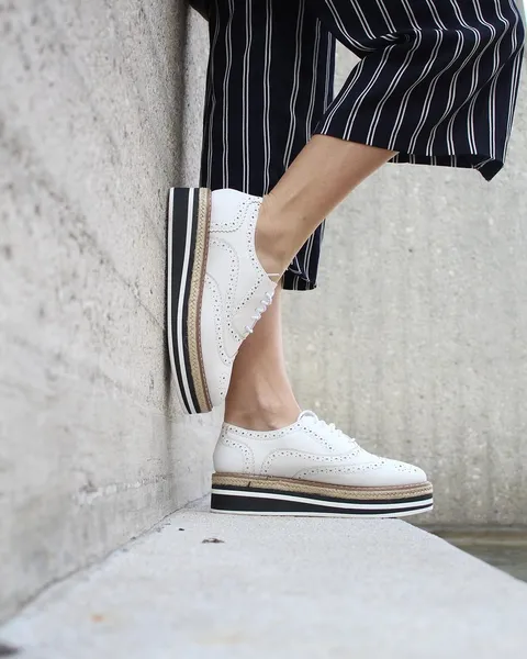 Pinstripe trousers worn with a white sneaker.