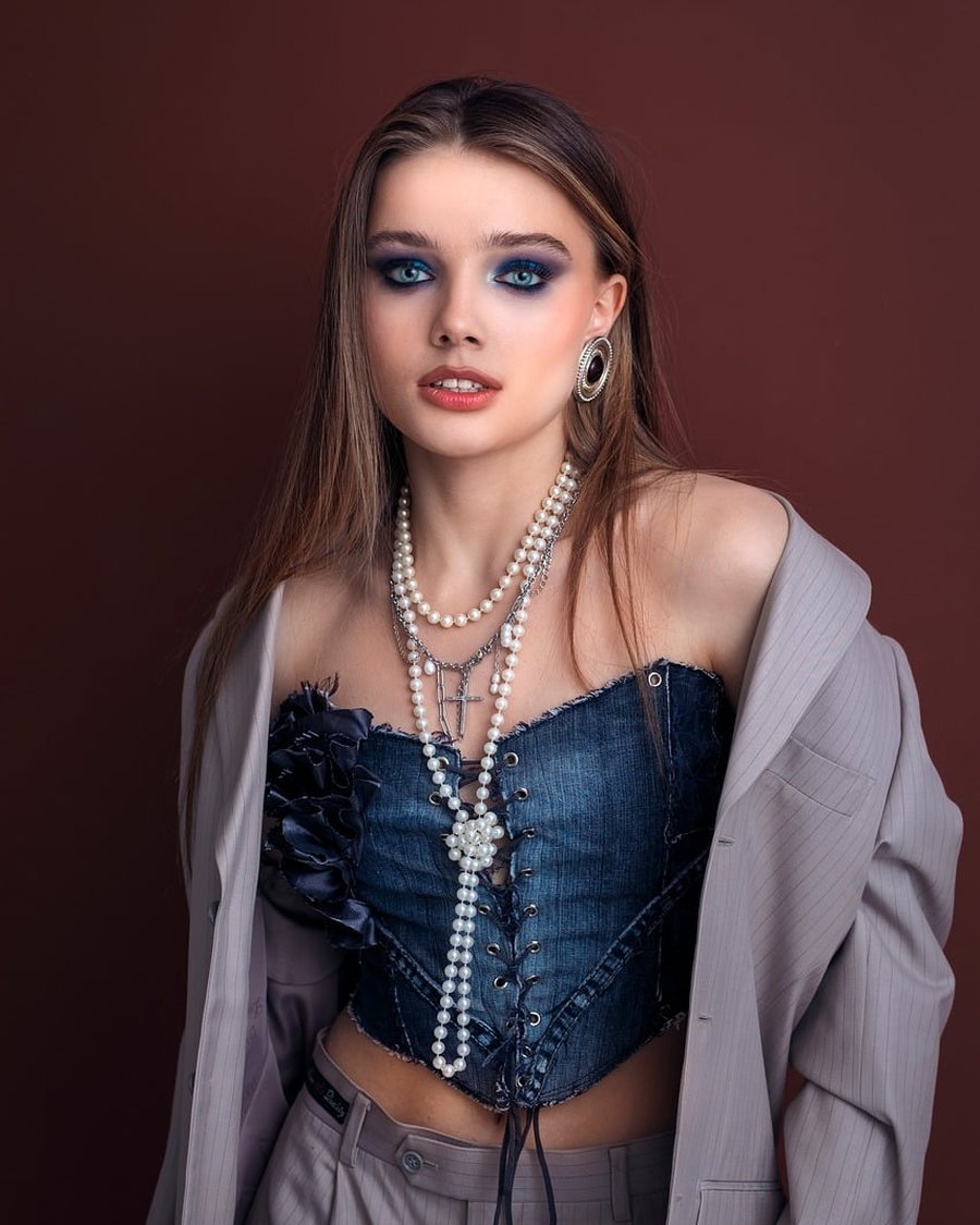 A woman in an open shirt over a cropped top.