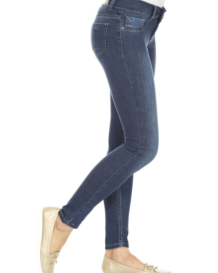 A woman in slim jeans and pale flats.