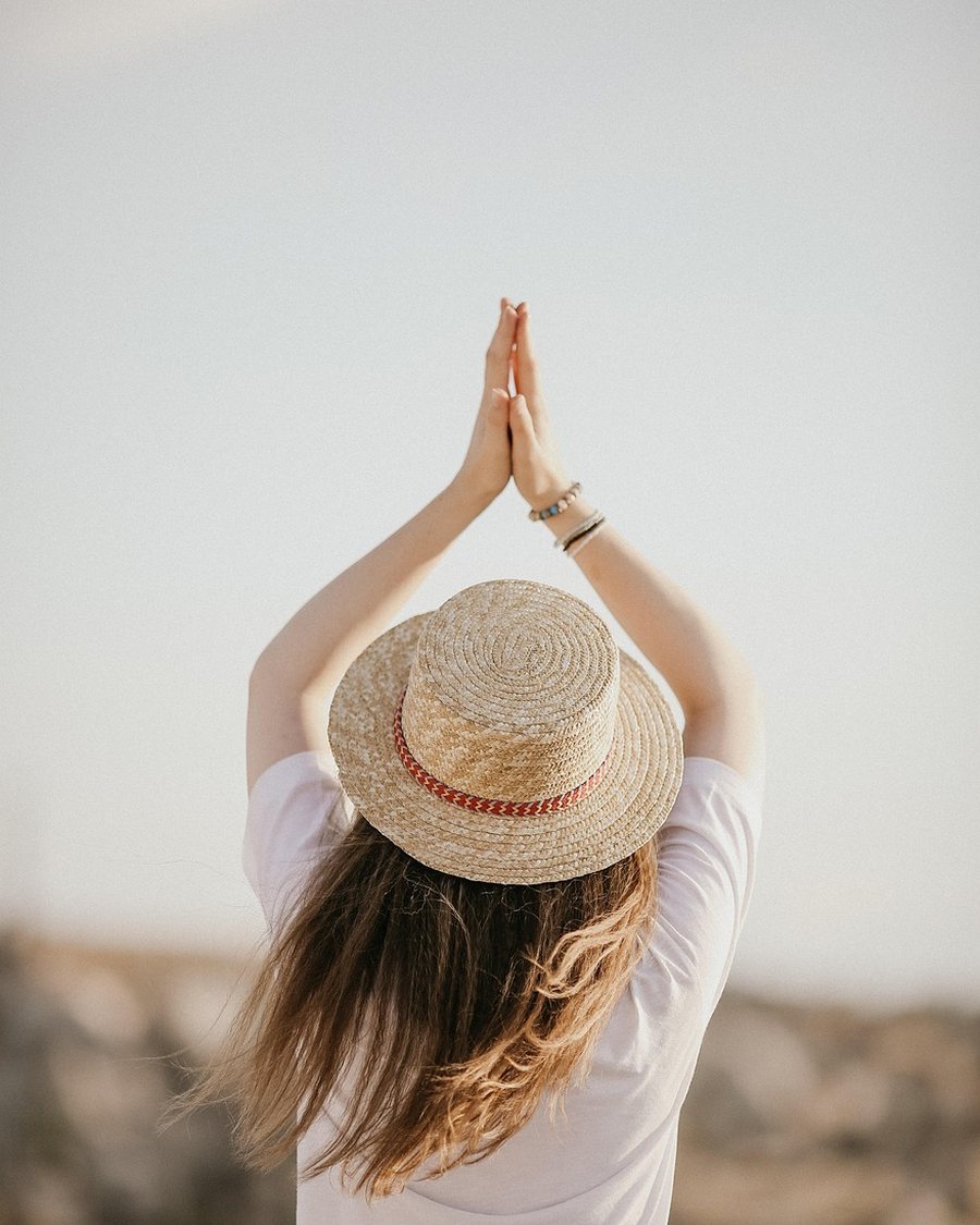 A woman in a white T-shirt photographed from behind.