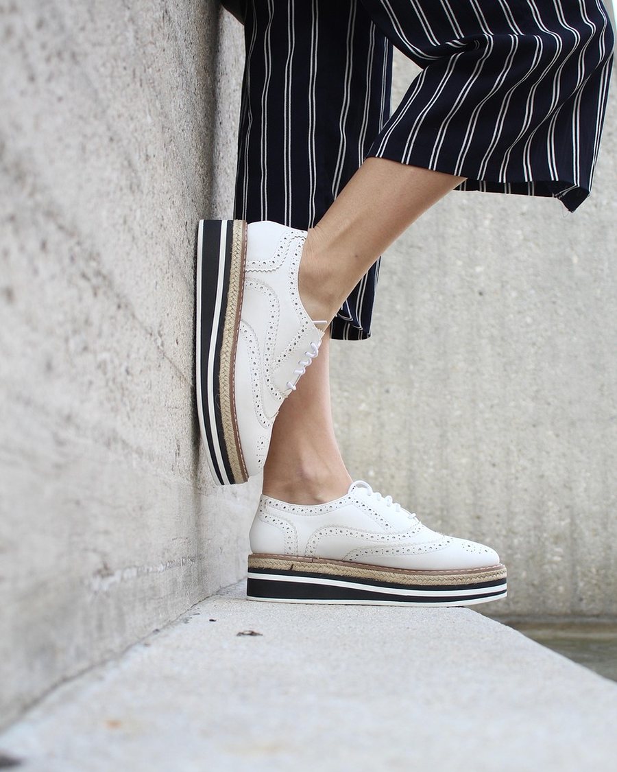 Pinstripe trousers worn with a white sneaker.
